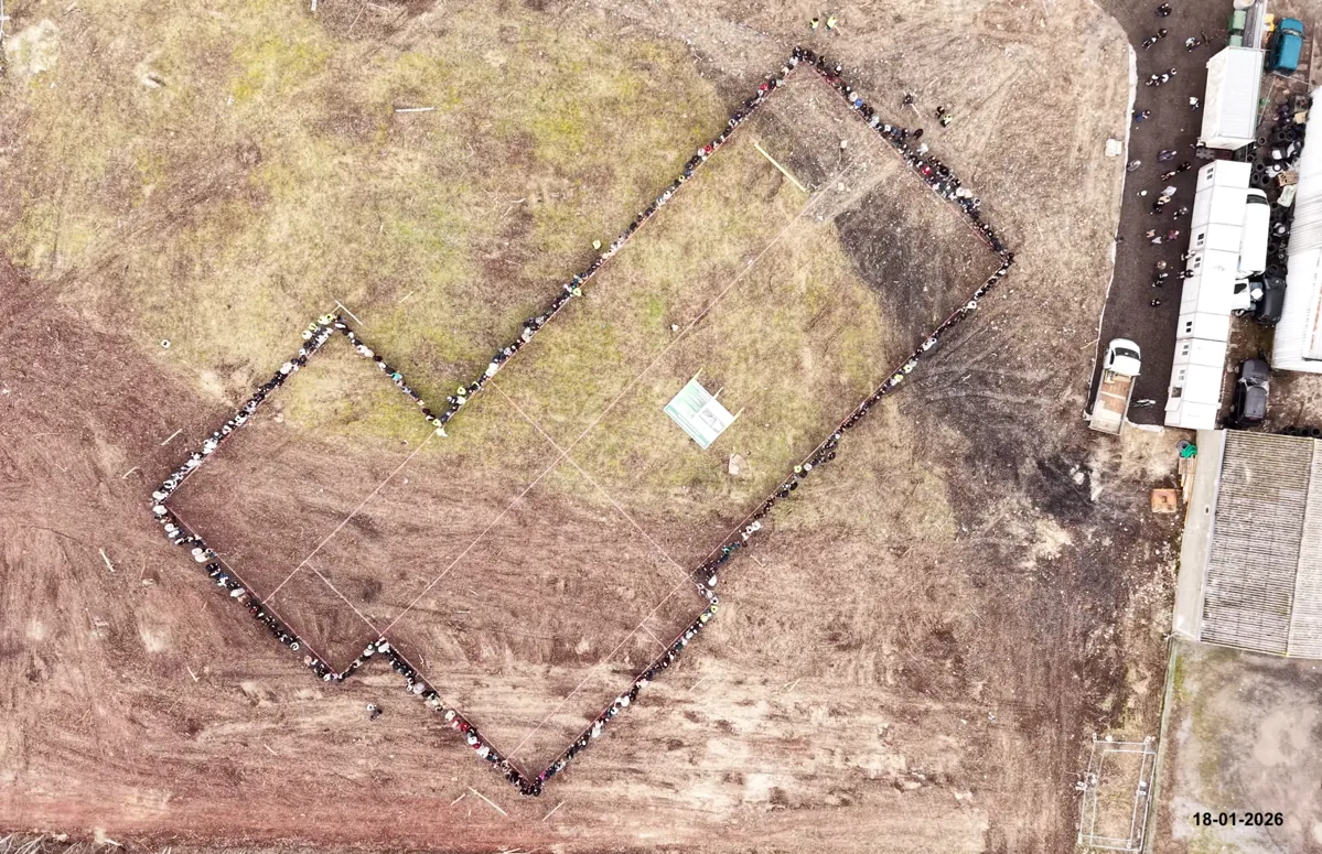 Vue aérienne : des centaines de fidèles, main dans la main, dessinent au sol le contour de la future mosquée